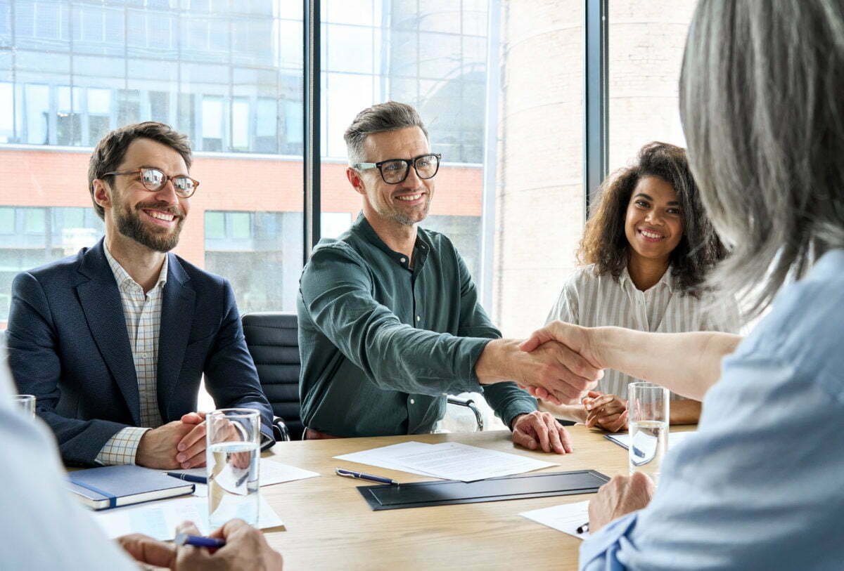 Home Happy businessman and businesswoman shaking hands